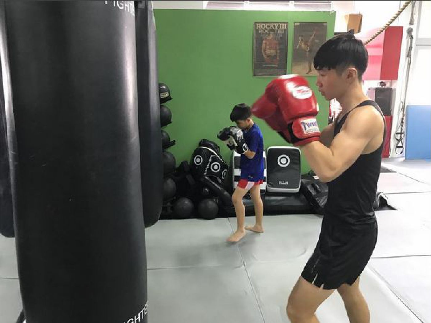Muay Thai Singapore West students of all ages doing bagwork